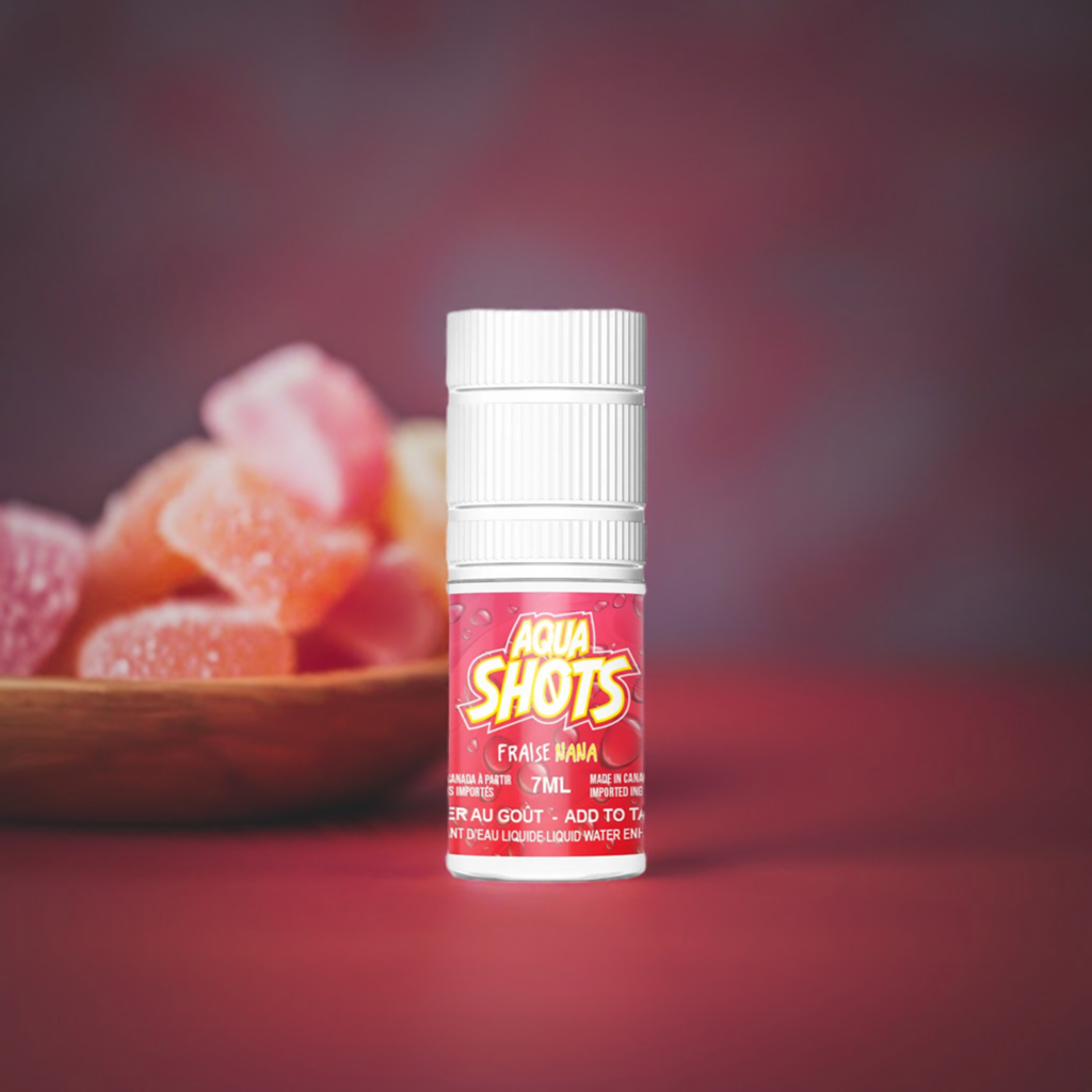 Bouteille compte-gouttes de saveur liquide concentrée AQUA SHOTS - Fraise Nana - 7ml, avec des fraises confites sur une table rose foncé.